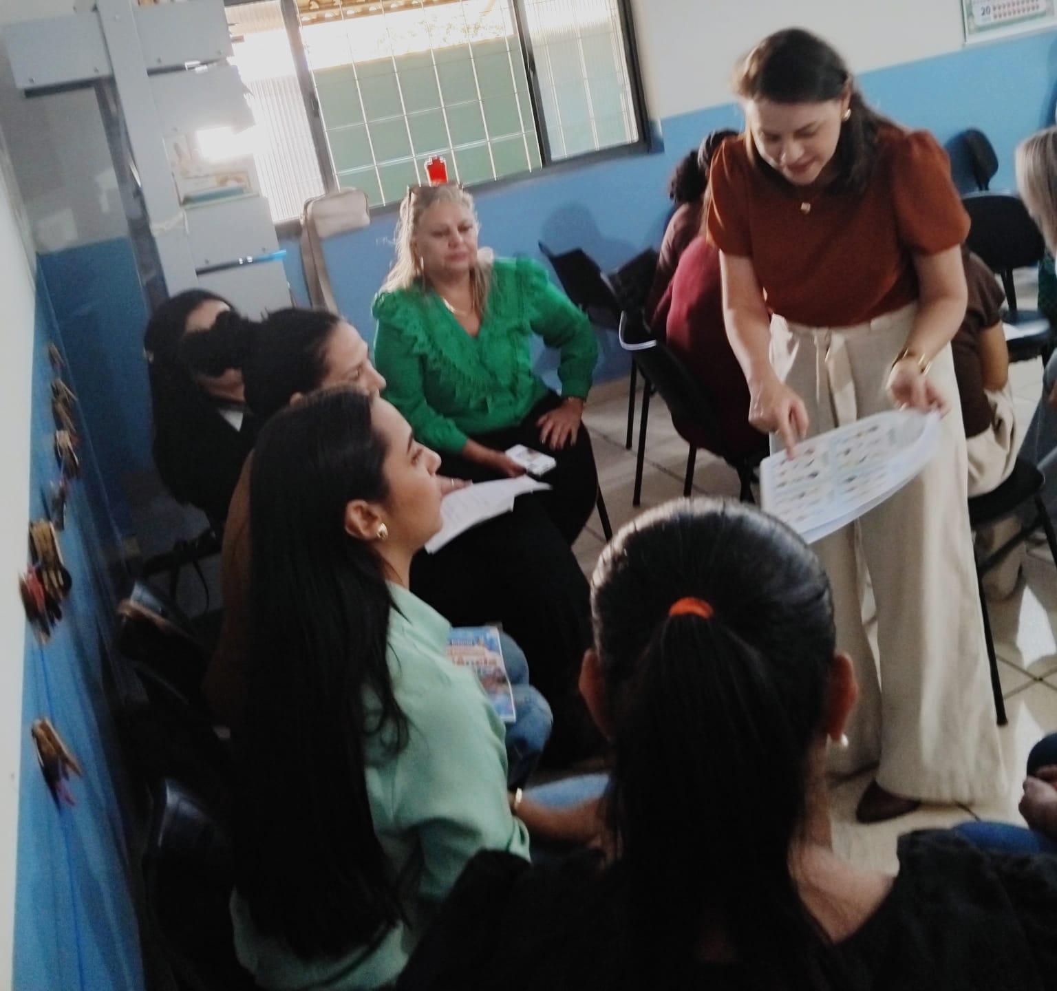 Formadora apresentando material pedagógico ao grupo